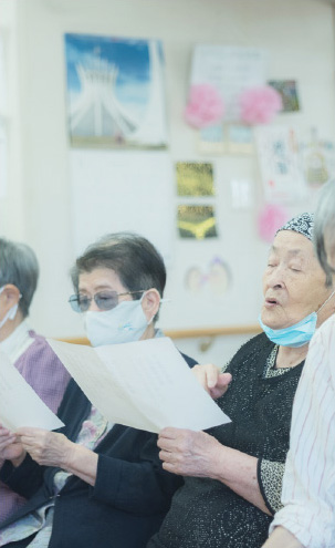 敬老会での一コマ。スタッフさんと一緒に歌を歌う利用者さん