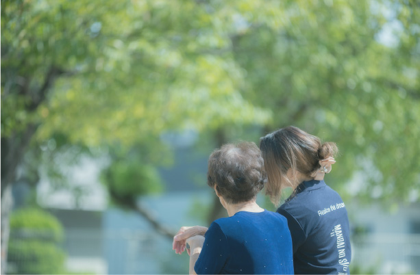 公園のベンチに座る住まいる万倍のスタッフと利用者