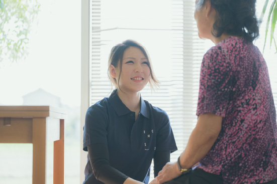 万倍の里の利用者の話を聞くスタッフ